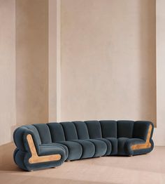 a blue couch sitting on top of a hard wood floor next to a white wall