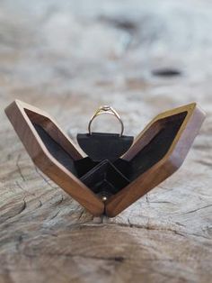 a wooden ring holder with two rings in it