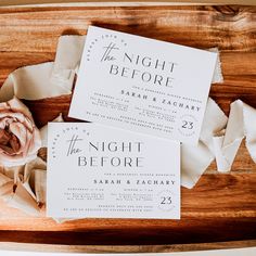 the wedding stationery is laid out on a wooden table with flowers and napkins