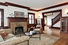 a living room filled with furniture and a fire place in the middle of a wooden floor