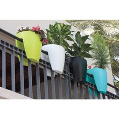 four planters are lined up on the balcony railing