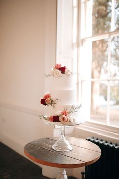 Three tier white iced wedding cake decorated with red, pink, and white rose decor White Rose Decor, Iced Wedding Cake, Cake Design Wedding, Rose Decorations, Groom Wedding Band, Winter Wedding Venues, Red Bridesmaid, Wedding Moodboard, Classic Wedding Cake