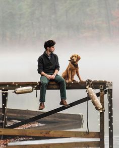 a man sitting on a dock with his dog