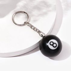 a black and white keychain with an eight ball on it