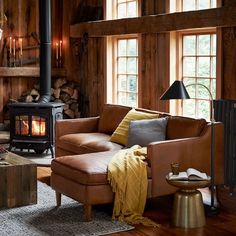 a living room filled with furniture and a fire place in front of a window covered in wood