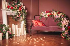 a living room filled with lots of flowers next to a fire place covered in candles