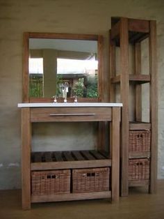 a bathroom vanity with two baskets under it and a mirror on the wall behind it