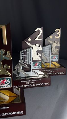 three trophies sitting on top of each other in front of a black background and white backdrop