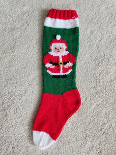 a christmas sock with santa clause on it laying on the floor next to a pair of shoes