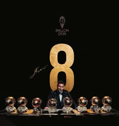 a man sitting at a table surrounded by soccer balls with the number 8 on it