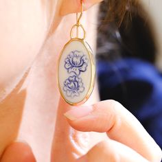 These porcelain earrings have been hand carved, and the drawing is also carved in, so each blue and white floral depiction is a bit unique. A lovely and classic statement earring that is surprisingly light in weight. Custom designed and framed in 14/20k gold-filled hardware, these gold earrings bring some modern blues to something with a bit more history. Porcelain stone piece is 1 1/4 inch in length Porcelain Jewellery, October Jewelry, White Ceramic Tiles, Porcelain Earrings, Broken China, Porcelain Jewelry, Earrings Collection, Slow Fashion, Statement Earrings