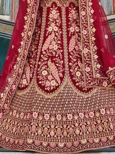 Make a striking statement on your special day with the richly intricate maroon bridal lehenga choli. This lavish ensemble is impeccably crafted from lush velvet, showcasing exquisite peacock work, intricate embroidery, and ornate zarkan stone embellishments. The attention to detail is evident, making this bridal lehenga choli truly breathtaking.
The semi-stitched design allows for customization up to 42 inches, ensuring a perfect fit for every bride. The set includes a soft net dupatta with an a Maroon Bridal Lehenga, Velvet Bridal Lehenga, Embroidered Velvet, Embroidered Art, Bridal Lehenga Choli, Net Fabric, Net Dupatta, Intricate Embroidery, Draped Fabric