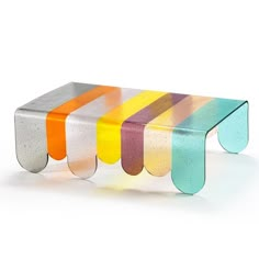 a multicolored glass table sitting on top of a white floor