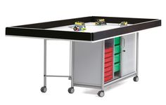 a toy table with drawers and wheels on the bottom shelf is shown in front of a white background