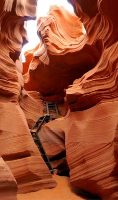 an image of the inside of a canyon with ladders going up it's sides