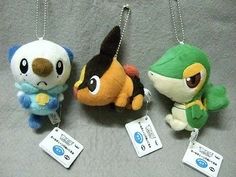 three small stuffed animals are hanging from chains