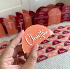 someone holding an orange guitar pick with the word christine on it