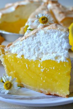 a slice of lemon meringue pie on a plate with daisies around it