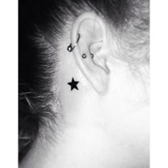 a woman with a black star tattoo on her ear