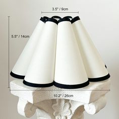 a white table lamp with black trimmings on it's base and measurements