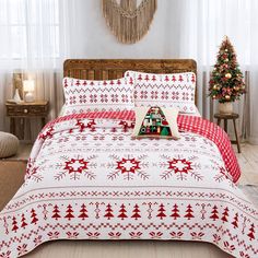 a bed with red and white christmas decorations on the sheets, pillows and pillow cases