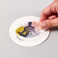 a person is holding a sticker with the image of a woman on it