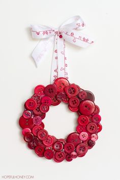 a red button wreath hanging on a white wall