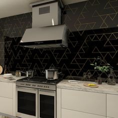 a kitchen with black and gold wallpaper, stainless steel range hood and stove top