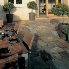 an outdoor dining area with potted plants on the patio and table set for four