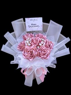 a bouquet of pink roses is in the center of a card holder with ribbons and bows