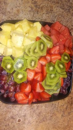 a tray filled with cut up fruit on top of a counter