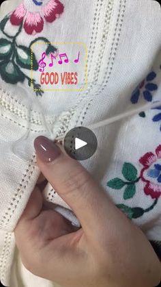 a person holding onto a white shirt with flowers on it and the words good vibes