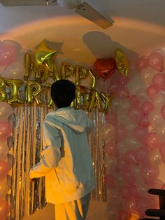 a person standing in front of balloons and streamers