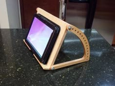 an electronic device sitting on top of a counter next to a wooden stand with a purple screen