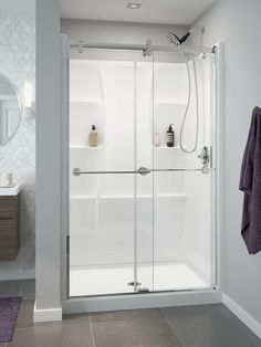 a bathroom with a walk in shower next to a white sink and purple rug on the floor