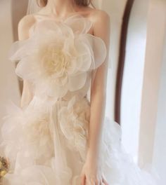 a woman wearing a wedding dress with flowers on it