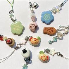 several charms are arranged on a white surface