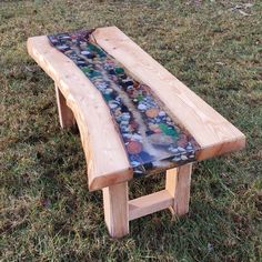 a wooden bench sitting on top of a grass covered field