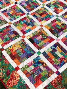 a colorful quilt is laying on the ground