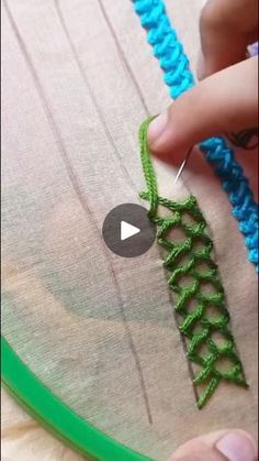 someone is working on something that looks like a crochet stitching pattern with green and blue yarn