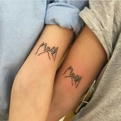 two people with matching tattoos on their arms