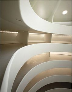 the interior of a building with curved white walls