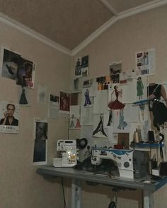 a sewing machine sitting on top of a table next to a wall covered in pictures