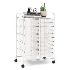 a white cart with lots of drawers on it's sides and some plants sitting on top