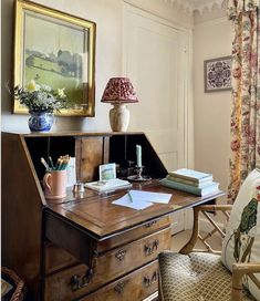 a wooden desk topped with a lamp next to a window