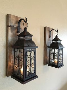 two lanterns are hanging on the wall next to each other, one is lit up