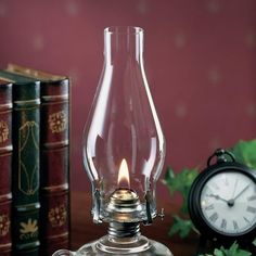 a glass vase with a lit candle in it on a table next to some books