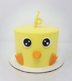 a yellow birthday cake with an odd face and number six on it's top