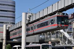 a train traveling over a bridge next to tall buildings on a city street in front of a traffic light