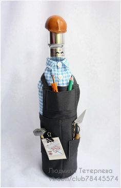 a bottle that has some pens and scissors in it, with a hat on top